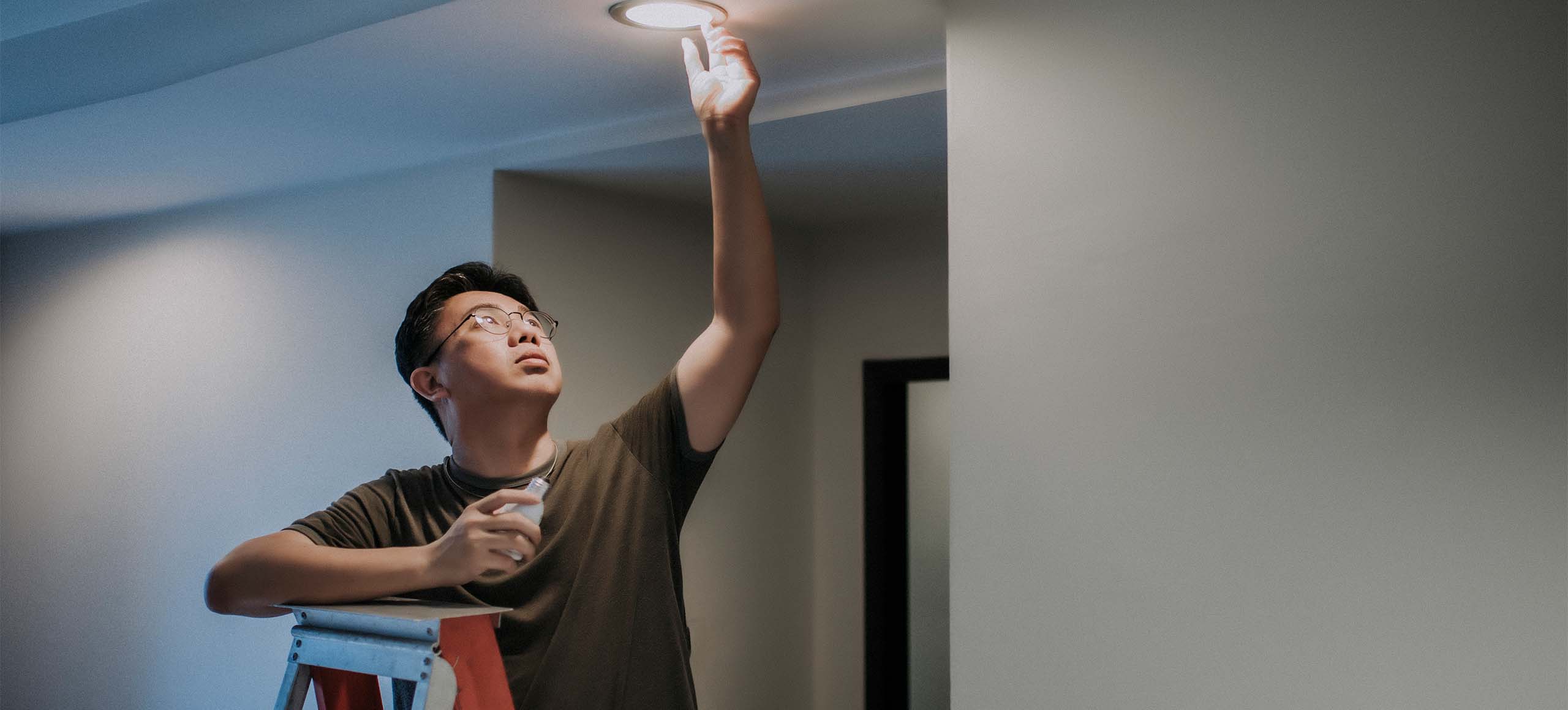 A man changing to an LED lightbulb